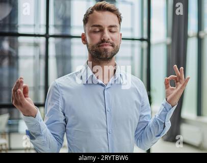 Young worker having break and resting after solving task Stock Photo