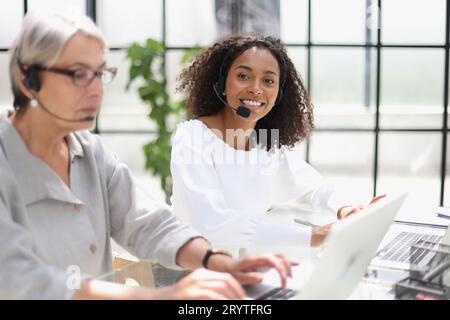 Young friendly operator woman agent with headsets working in a call centre. Stock Photo
