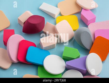 Heap of colorful cosmetic sponges on blue background. Top view Stock Photo