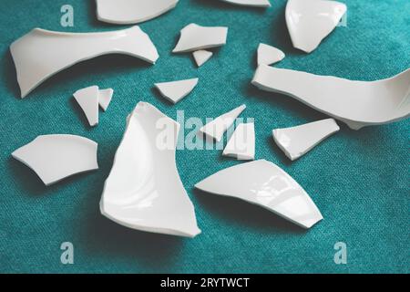 Splinters and Fragments of the broken white ware. Broken Plate, glass.  Pieces of shattered dishes. close-up, side view Stock Photo