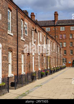row of old brick built terraced house in the north of England with iron railings, afternoon on a sunny day nobody around Stock Photo