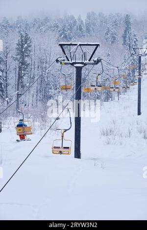 Teletsky Altai winter mountain ski resort near Iogach. Elevator on mount and forest background under snowfall Stock Photo