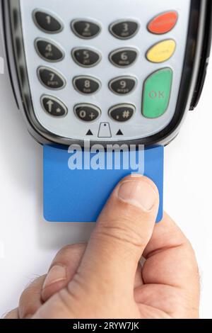 Hand put Credit card into payment terminal on white background Stock Photo