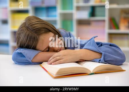 Schoolgirl napping at the desk at school after the lesson Stock Photo
