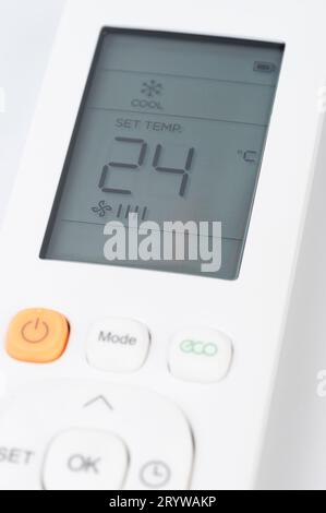 Set temperature on air conditioner with remote control buttons Stock Photo