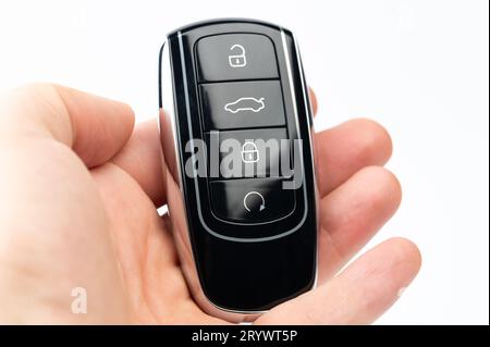 Modern black car key in palm hand macro close up view Stock Photo