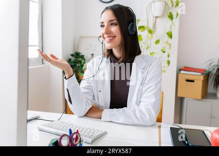 Young nutritionist female giving consultation to patient through video call Stock Photo