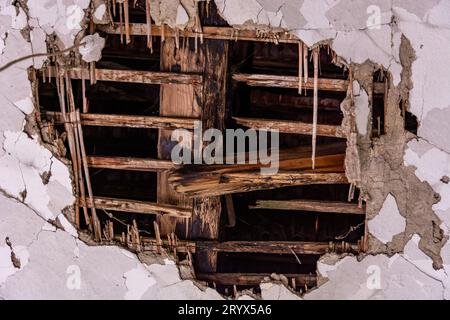 A massive hole in the ceiling revealing old, charred beams in an ancient house. Evokes the passage of time and the transience of aging materials Stock Photo