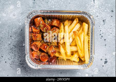 Traditional German currywurst with french fry served take away. Gray background. Top view. Stock Photo