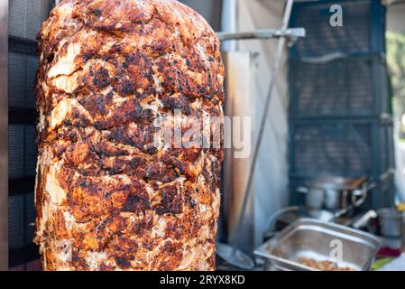 Grilled chicken meat on a vertical rotisserie used in traditional turkish street food Doner Kebab , burnt unhealthy meat concept. High quality photo Stock Photo