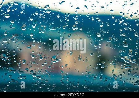 Rain drops on window glasses surface with sunset. drops on glass spray on window background for dark textÂ view selective focus Stock Photo