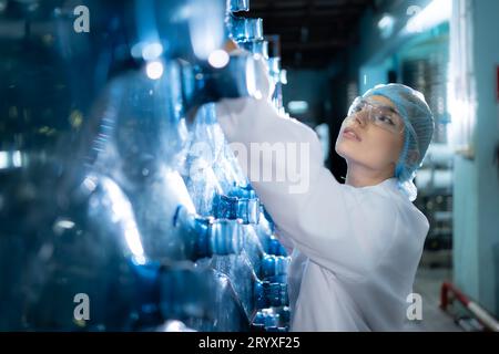 Female researcher carrying out scientific research in drinking water factory Stock Photo