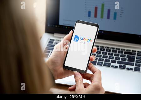Smartphone with Google Docs application on screen. Close up view of mobile phone holding by a woman. Stock Photo