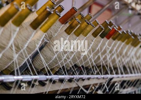 Spinning machinery with spindles close up. Stock Photo