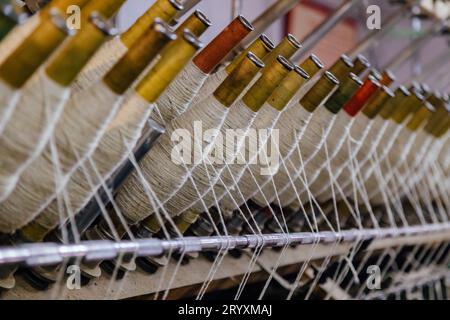 Spinning machinery with spindles close up. Stock Photo