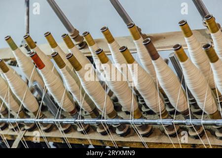 Spinning machinery with spindles close up. Stock Photo