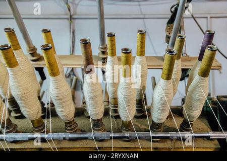 Spinning machinery with spindles close up. Stock Photo