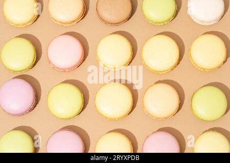 An assortment of macarons are neatly arranged in rows on a flat surface Stock Photo