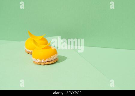 A tray of freshly baked yellow cupcakes with delicious white whipped icing on top and green background Stock Photo