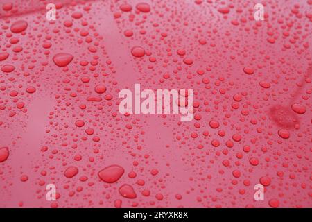 Water drop abstract background wallpaper on red color wet surface area. Selective focus included. Stock Photo