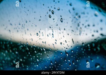 Rain drops on window glasses surface with sunset. drops on glass spray on window background for dark textÂ view selective focus Stock Photo