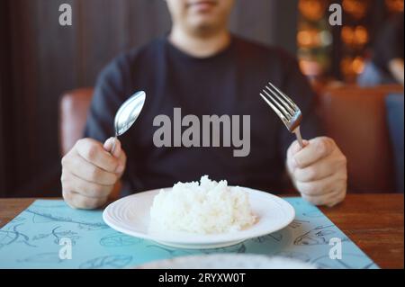Man eating rice enjoying a meal in restaurant. man having dinner. Stock Photo