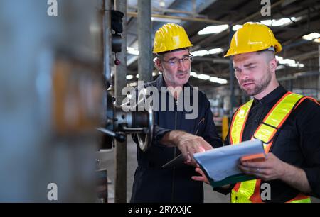 Engineers and technicians check the electrical system and repair the mechanical system in the control cabinet of the machine. in Stock Photo