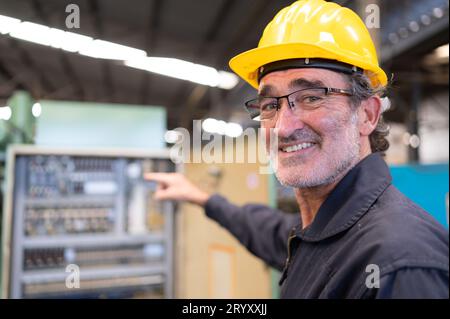 Senior engineer inspects the electrical system and repairs the mechanical system in the machine control cabinet. in order for th Stock Photo