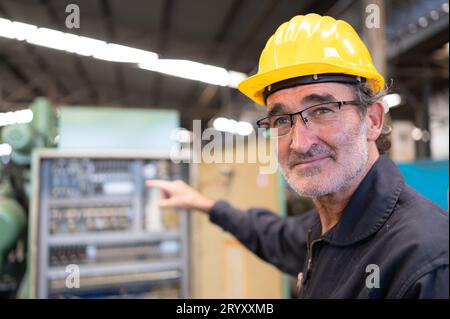 Senior engineer inspects the electrical system and repairs the mechanical system in the machine control cabinet. in order for th Stock Photo