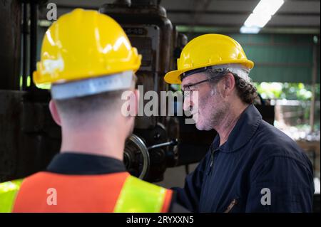 Engineers and technicians check the electrical system and repair the mechanical system in the control cabinet of the machine. in Stock Photo