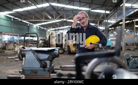 Senior engineer with fatigue from long and hard work Stock Photo