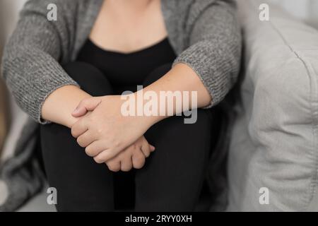 Sad Overweight plus size woman thinking about problems on sofa upset girl feeling lonely and sad from bad relationship or Depres Stock Photo