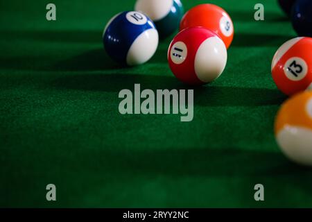 Man's hand and Cue arm playing snooker game or preparing aiming to shoot pool balls on a green billiard table. Colorful snooker Stock Photo