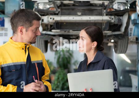 Engineers and auto repair technicians must use technology to detect faults in the operation of the engine of customer cars broug Stock Photo