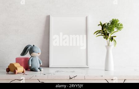 Empty photo frame mockup on white marble table with rabbit doll houseplant plant and wooden toy car. Art and interior home decor Stock Photo