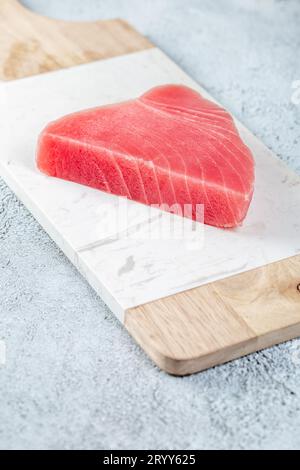 Raw tuna steak on white concrete background. Stock Photo