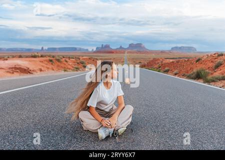 Happy girl on the famous road to Monument Valley in Utah. Amazing view of the Monument valley. Stock Photo