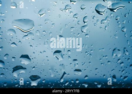 Rain drops on window glasses surface with sunset. drops on glass spray on window background for dark textÂ view selective focus Stock Photo