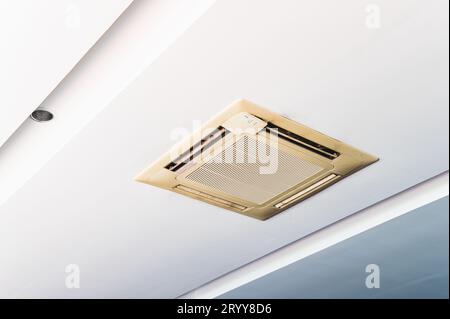 Old cassette type air conditioner on ceiling indoor. Electronics and purifier concept. Stock Photo
