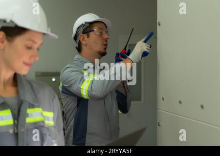 Electric power engineering team inspecting system of a large solar energy storage station in the middle of the field of solar ce Stock Photo