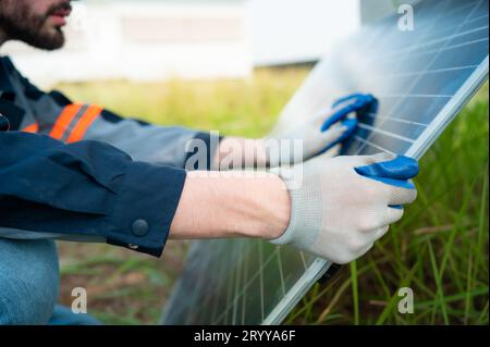 An electrical engineer is inspecting a solar cell that has been used for some time, installed on a field hundred acres of grass. Stock Photo