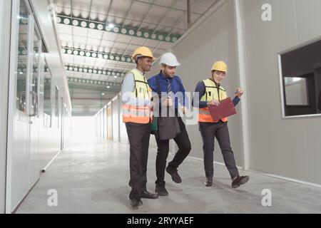 The warehouse manager advises the two employees on how to organize the shelves in a vast warehouseand and invited to dance to en Stock Photo