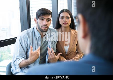 Psychotherapist inquiring about symptoms occurring within mind from patients with mental health problems in hospital. Group psyc Stock Photo
