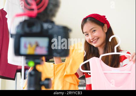 Beauty Asian Vlogger blogger interview with professional DSLR digital camera film video live. Woman coaching trading and review Stock Photo