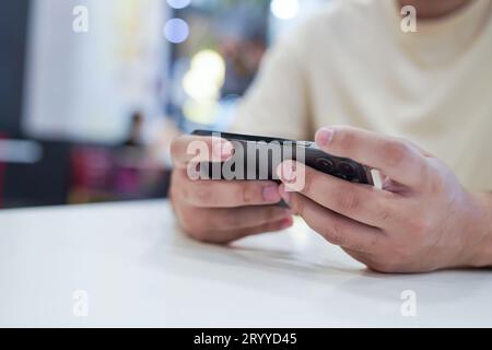 Man playing game on mobile phone. gamer boy playing video games holding SmartphoneÂ working mobile devices. cell telephone techn Stock Photo