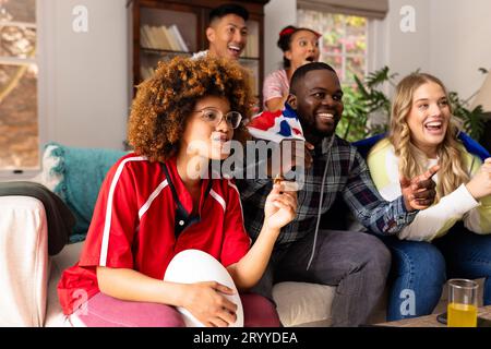 Happy group of diverse friends with rugby ball and snacks supporting at ...