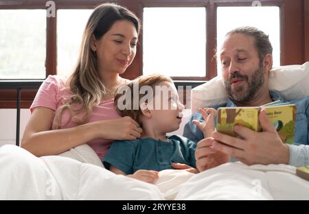 Little boy's father read stories to children before going to bed to unwind and sleep soundly until the morning. Stock Photo