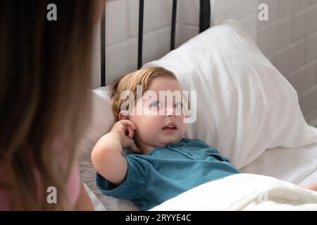 Little boy's mother read stories to children before going to bed to unwind and sleep soundly until the morning. Stock Photo