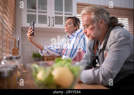 Father and daughter in the kitchen of the house, Two ages two generations with different lifestyle but can live happily together Stock Photo