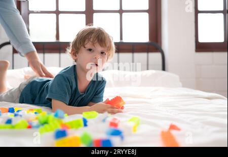 Father with little boy have fun playing with your new toys in the bedroom together. Toys that enhance children's thinking skills Stock Photo